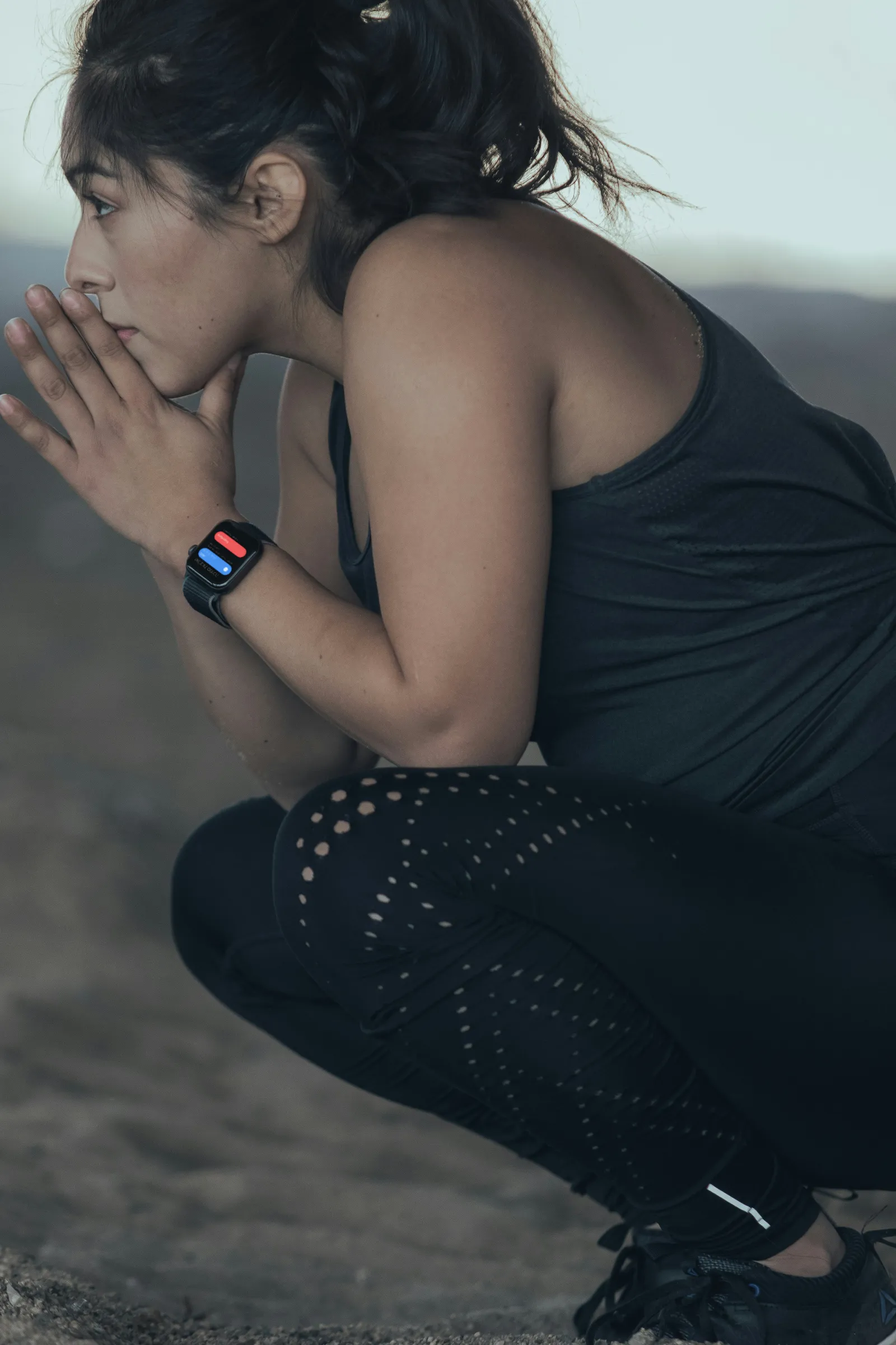 אישה נחה במצב כריעה עם Pushanova ב-Apple Watch שלה